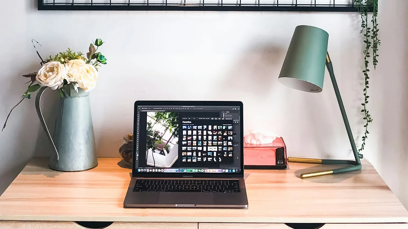 Warm workspace with a laptop, flowers and a lamp