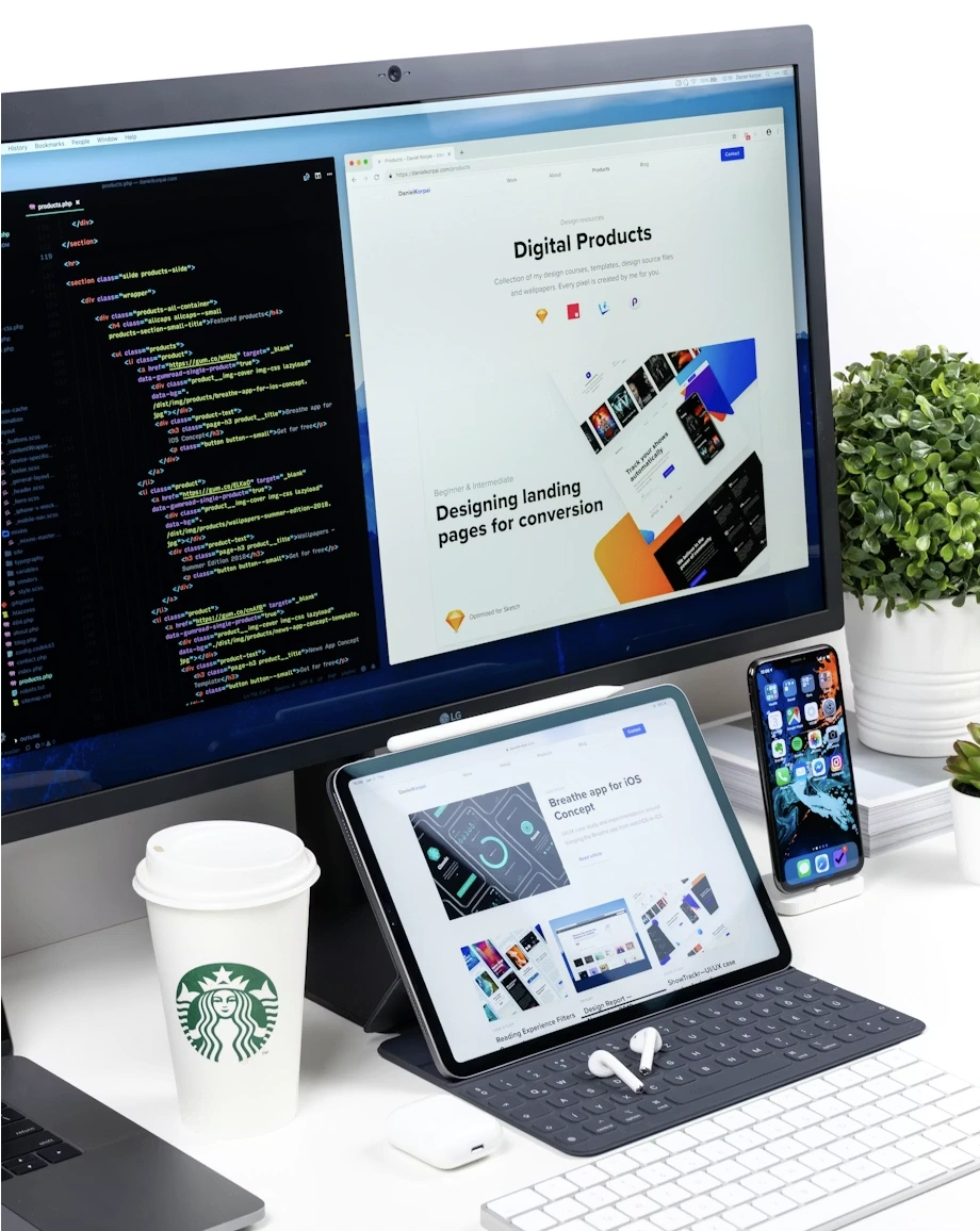 Workspace Norvio Studio : moniteur avec code et site web en design, tablette, smartphone et café